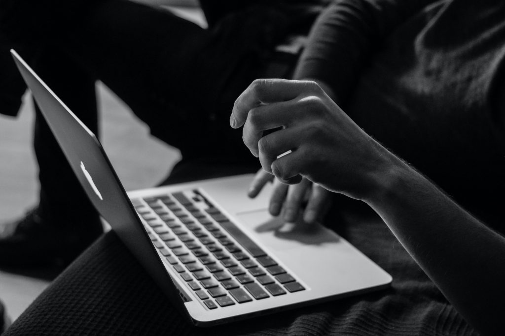 Grey image on someone working on an Apple notebook