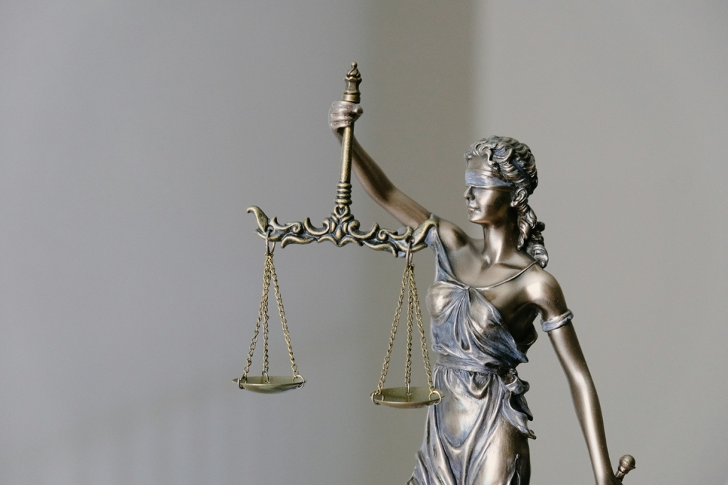 Metal figurine of a blindfolded person holding a set of scales